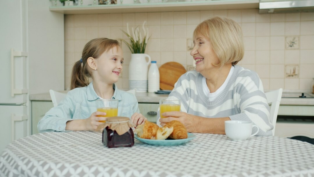 Interview scene between a journalist and an elderly woman at her kitchen table